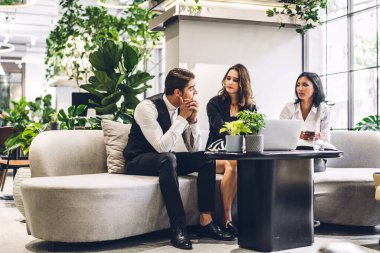 Profesyonel iş grupları yeni projeyle strateji paylaşım fikrini tartışıyor. Yeşil santral terasında çalışan ve konuşan yaratıcı iş adamları modern çalışma odalarında çalışıyor.