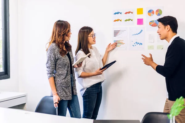 Casual creative happy two smile asian business people plan strategy analysis and brainstorm putting post it sticker note to share idea for startup project on glass board at modern office