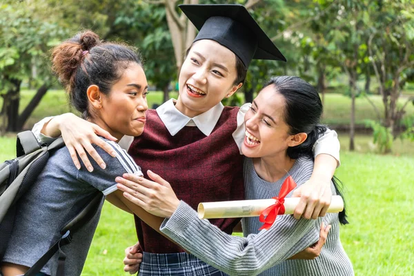 Successful of student young woman and bachelor gowns with diplomas graduate hugging her friend at university.Celebrating graduation and education concept