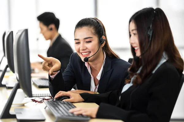 Group of happy call center smiling asian business operator customer help support team phone services agen working and talking with headset on desktop computer at call center office