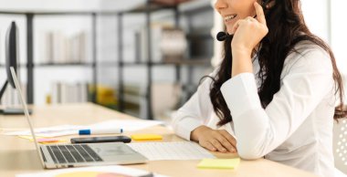 Mutlu çağrı merkezi gülümseyen iş kadını operatörü grubu çağrı merkezinin bilgisayarında çalışan ve kulaklıkla konuşan ekip telefon hizmetlerini desteklemeye yardım eder.