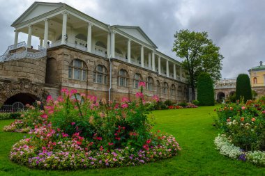 Sonbahar parkında çiçek açan yataklar antik bir saray galerisinin arka planında