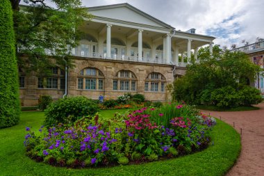 Sonbahar parkında çiçek açan yataklar antik bir saray galerisinin arka planında
