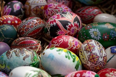 Çeşitli ellerle samanla boyanmış Paskalya yumurtaları.