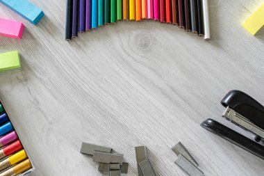 Gökkuşağı ve okul çocuklarına ahşap bir masa üzerinde erzak üreten renkli kalemlerin yakın çekimi.