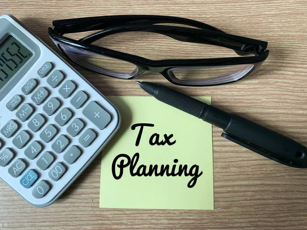 Tax planning text on sticky note with calculator, glasses and pen — Stock Photo, Image