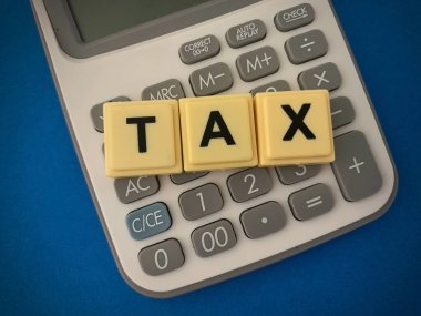 Küp bloklar ve hesap makinesinin üstünde vergiler var. İş konsepti