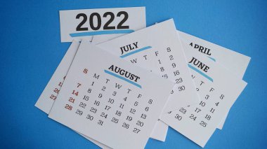 Ağustos ayı kapanışı, çeşitli ayların takviminin arka planında. 2022 Yeni Yıl konsepti
