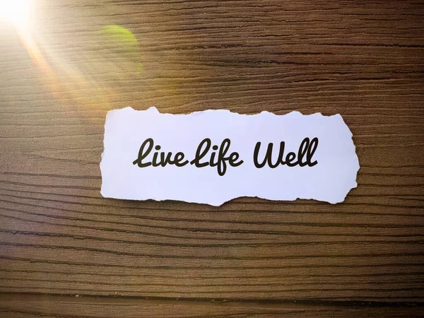 Motivational and inspirational quotes - Live life well. Small rip paper and wooden floor background. — 스톡 사진