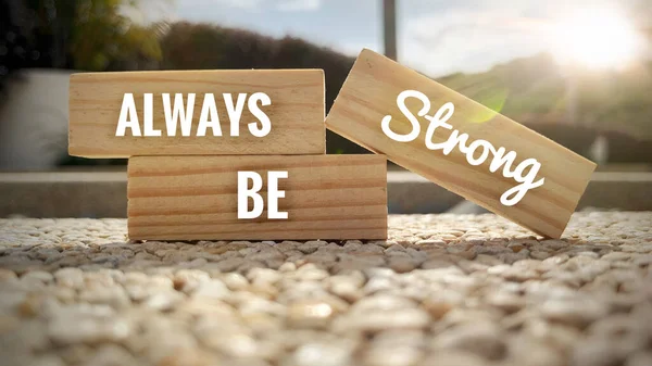 Text on wooden blocks - Always be strong. With shining light background. Motivational concept — Stock Photo, Image