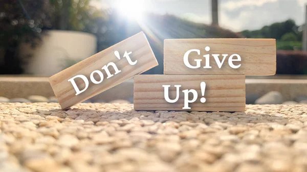 Text on wooden blocks - Dont give up. With blurred park and shining light background. Motivational concept. — Stockfoto