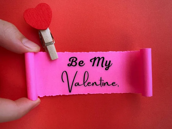 Be my valentine text on ripped paper with red paper background. Valentines Day concept. — Photo