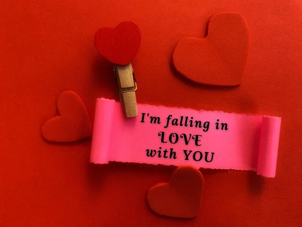 Im falling in love with you text on a small piece of torn paper with heart shape and red color background. Valentines Day concept. — Photo