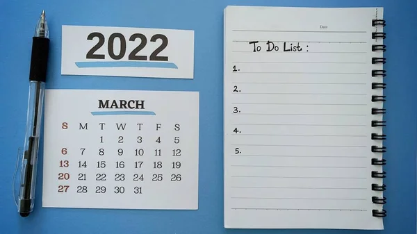 Hand written to do list text on notepad for month of March with pen and blue background. 2022 new year concept. — Zdjęcie stockowe