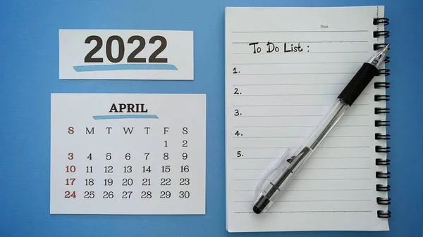 To do list text on note book with pen and April calendar month 2022 background. 2022 new year concept. — Zdjęcie stockowe