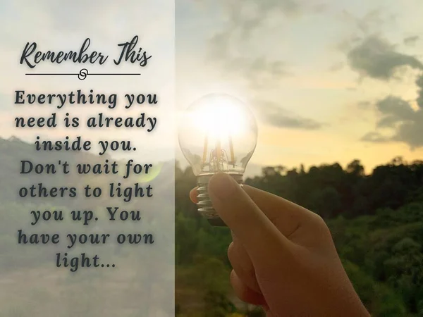 Inspirational and motivational quotes - Everything you need is already inside you. Dont wait for others to light you up. You have your own light. With hand holding a light bulb and blurred background — Stockfoto