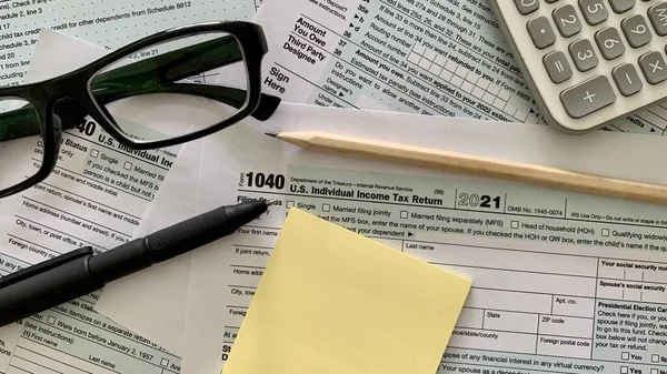 1040 US individual tax form, pen, yellow sticker, pencil calculator and pen. — Foto Stock