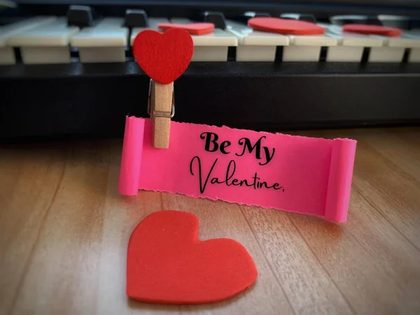 Be my Valentine text on torn paper with keyboard, brown table and heart shape background. Valentines Day concept. — Photo