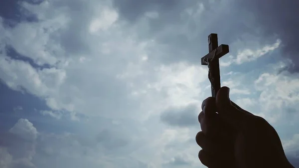 Hand houden heilige kruis met heldere hemel achtergrond. Christendom concept. — Stockfoto