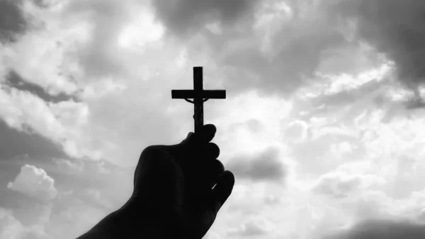 Hand houden heilige kruis met heldere hemel achtergrond. Christendom concept. — Stockfoto