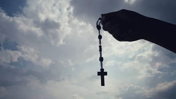 Concept religieux chrétien de la main tenant un Saint Rosaire avec fond de ciel. — Photo