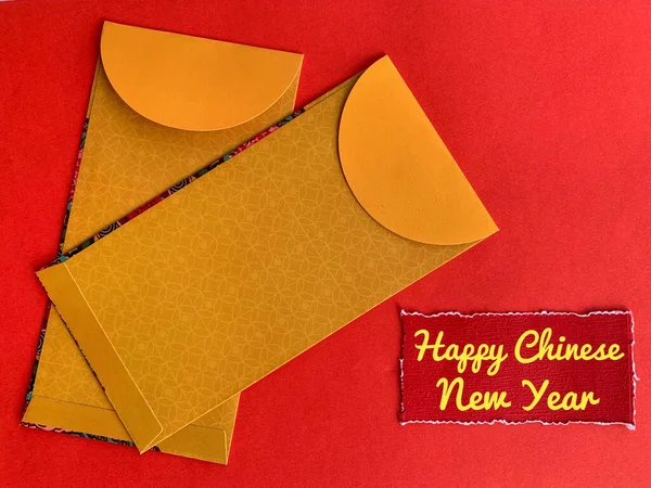 Enveloppes jaunes avec le Nouvel An chinois souhaite texte sur papier rouge déchiré. Concept de célébration. — Photo