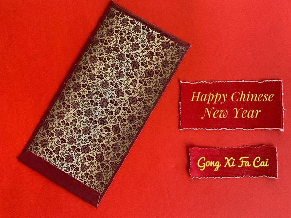 Dunkelroter und goldener Umschlag zum chinesischen Neujahrsfest mit Neujahrswunschtext auf zerrissenem rotem Papier. — Stockfoto
