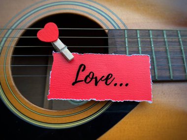 Gitar arkaplanlı yırtık kağıda yazılmış aşk metni. Sevgililer günün kutlu olsun..