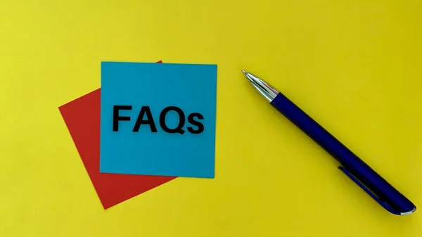 FAQs texto en azul post nota con lápiz y fondo amarillo. Concepto empresarial. — Foto de Stock
