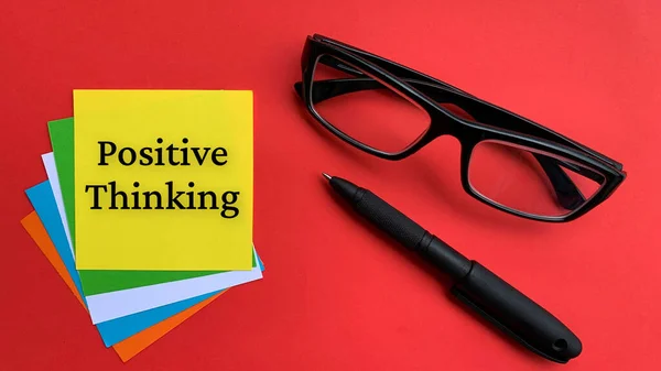 Pozitivní myšlení text na žlutý notepad s červeným krytem a pozadí brýlí. Motivační koncept — Stock fotografie