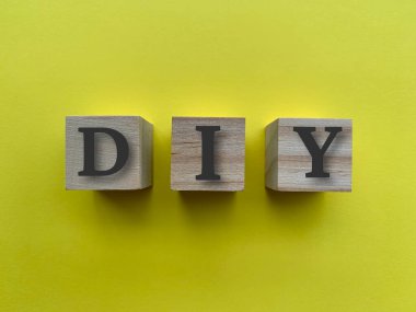 Tahta bloklarda sarı arkaplanlı diy alfabesi.