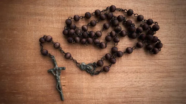 Bovenaanzicht van de Heilige Rozenkrans op houten tafel. Christendom concept. — Stockfoto