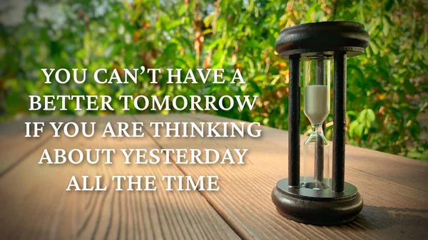 Если вы все время думаете о вчерашнем дне, у вас не будет лучшего завтрашнего дня. Со стеклом минут и зеленым садом. — стоковое фото