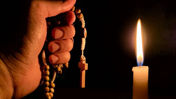 Keresztény ima - Szent Rózsafüzér és gyertya éjszakai háttérrel. Keresztény fogalom. — Stock Fotó