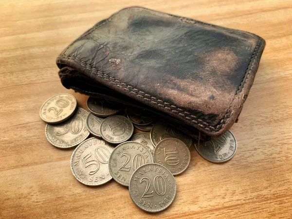 Vieille pièce isolée et portefeuille en cuir sur table en bois marron. Concept d'argent. — Photo
