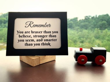 Oyuncak tren ve doğa geçmişi olan kağıt çerçevesinde motive edici ve ilham verici bir alıntı..