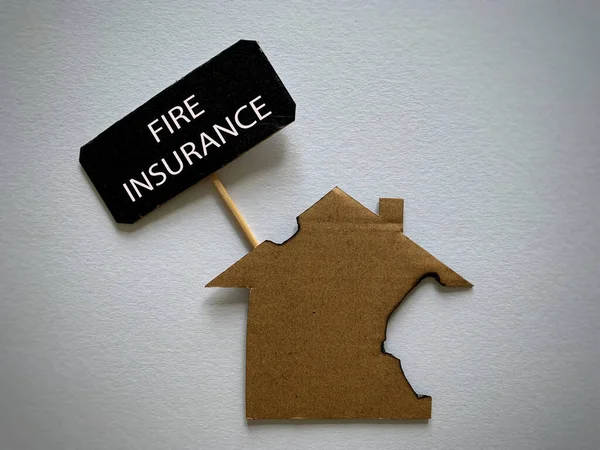Tekst ubezpieczenia przeciwpożarowego ze spalonym wzorcowym tłem domu. Pojęcie ubezpieczenia. — Zdjęcie stockowe