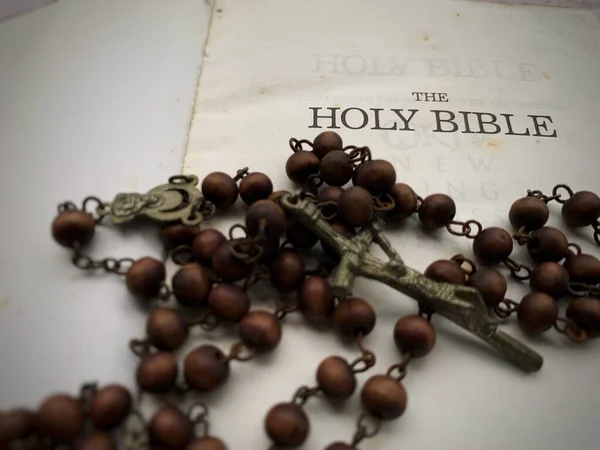 Primo piano del Santo Rosario con sfondo Sacra Bibbia. Concetto di cristianesimo. — Foto Stock