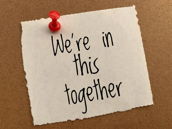 We are in this together text on yellow torn notepad. Conceptual. — Stock Photo, Image