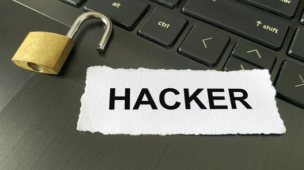 Vista de cerca del texto en papel roto - Hacker. Con taquilla borrosa y fondo portátil. Concepto contraseña — Foto de Stock