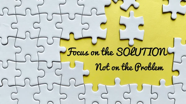 Focus on the solution. Not on the problem text on yellow cover surrounded with missing white puzzle. Business concept — Stock Photo, Image