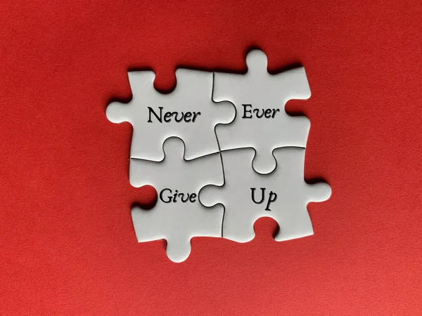 White jigsaw puzzle pieces and text - Never ever give up. Business and life motivational concept — Stock Photo, Image
