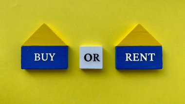 Ahşap ev modeli üzerine sarı renkli kağıt kaplamalı metin al ya da kirala. Emlak yatırım kavramı.