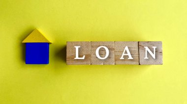 Kredi sözcüğünün üst görüntüsü ve sarı kağıt arka planlı ahşap ev.