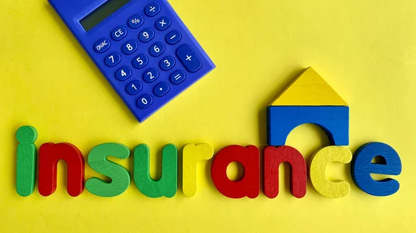 Widok górny słowa Ubezpieczenie, kalkulator i drewniany model domu z żółtym tle papieru. — Zdjęcie stockowe