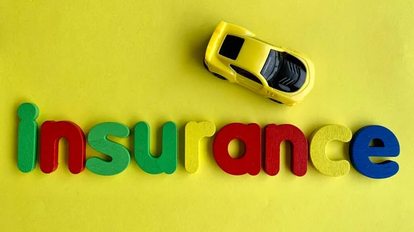 Κάτοψη του κειμένου - Ασφάλιση με αυτοκίνητο μοντέλο επάνω πλευρά προς τα κάτω και κίτρινο φόντο. — Φωτογραφία Αρχείου