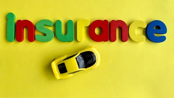 Widok z góry tekstu Ubezpieczenia i modelu samochodu z żółtym tle. Pojęcie — Zdjęcie stockowe