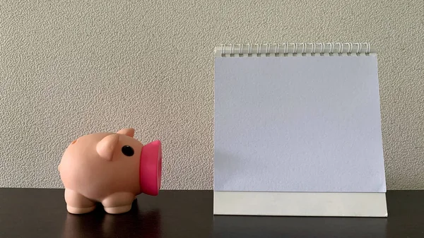 Ευθεία θέα του κενού λευκό σημειωματάριο με piggy πίσω. Αντιγραφή έννοιας χώρου — Φωτογραφία Αρχείου