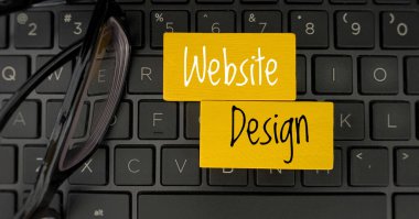 Tahta bloklarda dizüstü bilgisayarlı web sitesi tasarım metninin üst görünümü.