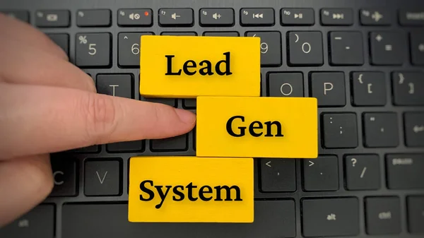 Top view of Lead Gen System text on yellow wooden blocks with laptop background.